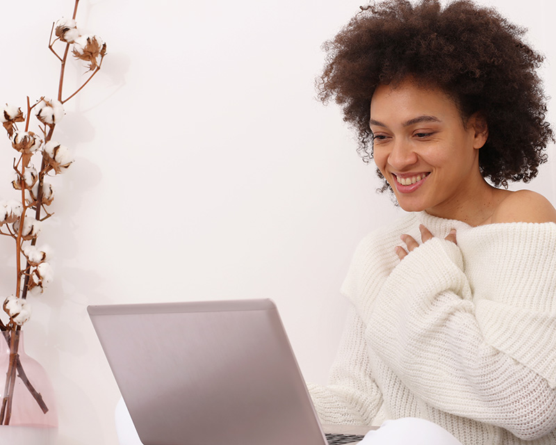 Young black woman at a laptop doing a Guided Meditation Group in Valley Stream