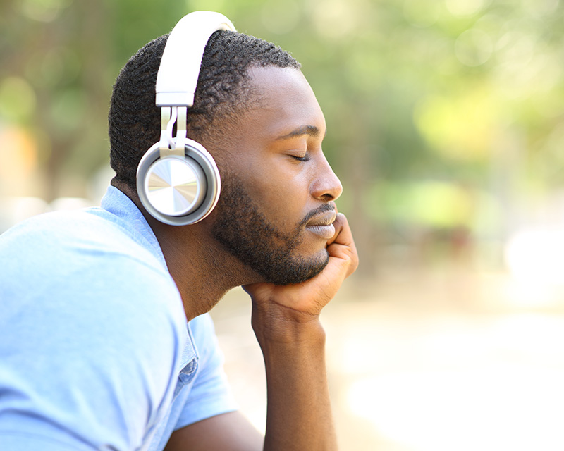 Black man with headphones listening to a guided mediation during group in Valley Stream, NY