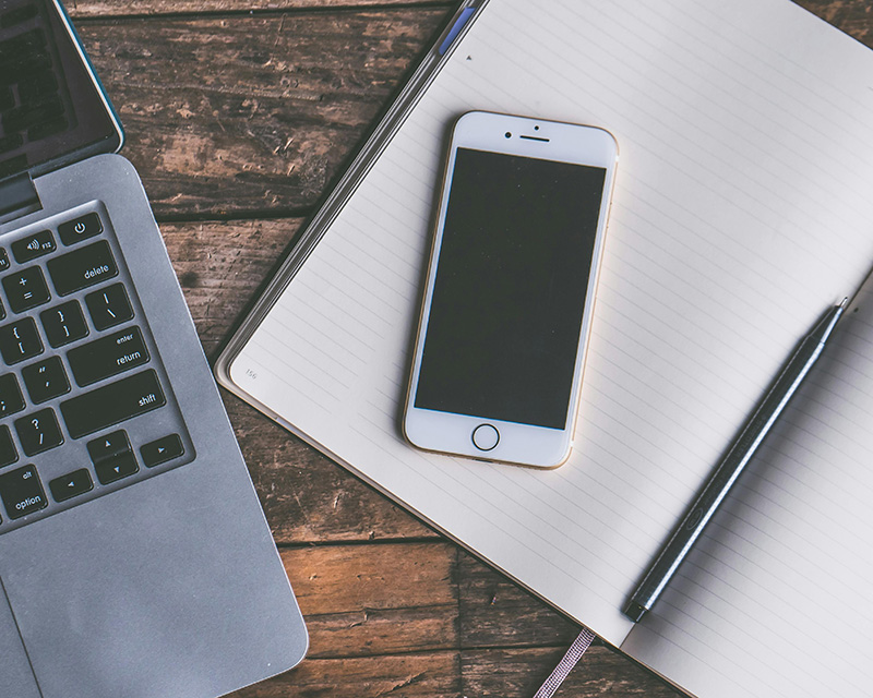 iPhone and laptop with journal