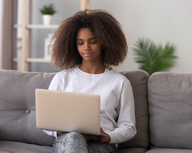 Black teenager with a laptop getting ready for therapy for teens in Lynbrook, NY